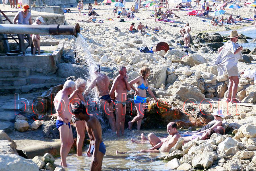 Туристите използват постоянно течащата минерална вода на плажа, която се влива в морето. 