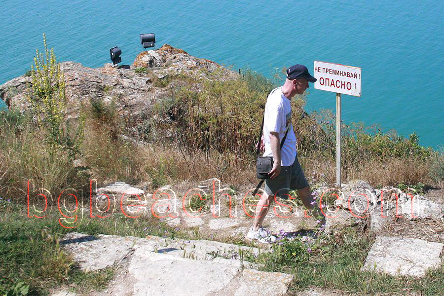 A tourist disrespects the sign not to go further.